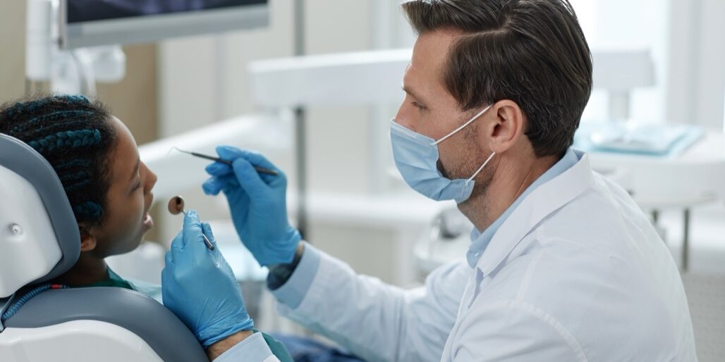Side,View,Portrait,Of,Male,Dentist,Wearing,Mask,While,Working