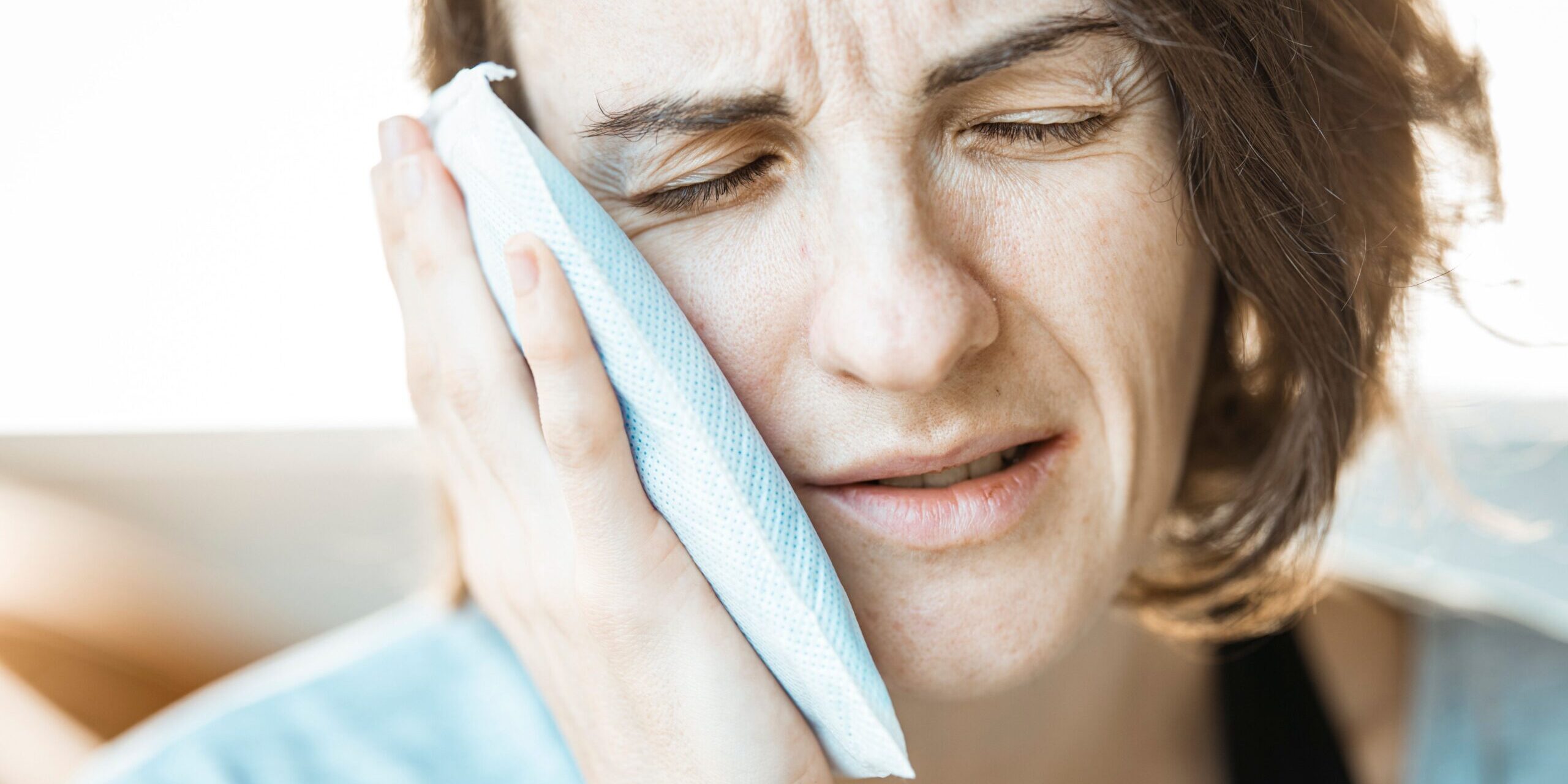 what-counts-as-a-dental-emergency-london-ontario Woman holding a cold compress while waiting to see an emergency dentist near me in London, Ontario